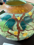 Detail of decorative fruit and branch motif on ceramic surface