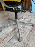 Close-up of Eames EA108 chair's five-star aluminium swivel base and central stem.
