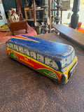 Side view of GTP 552 Motorways tinplate coach showing full lithographed body with blue roof, red and yellow sides, GTP Motorways lettering and row of illustrated passengers in windows