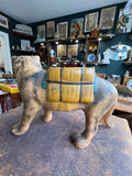 Left side view of the vintage ceramic tiger planter showing the full profile with mustard yellow saddle planter on back, dark grid-line detailing, teal blue strap, and matte grey-brown body glaze.