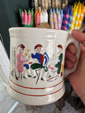 Hand holding an antique Staffordshire frog mug showing the hand-painted figural scene and handle