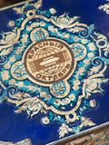 Close-up of Krasny Oktyabr Cyrillic logo on Antique sweet tin