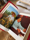 Two colour photographic plates of Mao Tse-Tung, one in a cornfield, one seated at a table, inside the book.