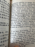 Open page of "Little Red Book" showing English text on Party criticism and self-criticism.