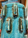 	Close-up of raised blocks on a turquoise vase with brown wipe glaze and fine crackle